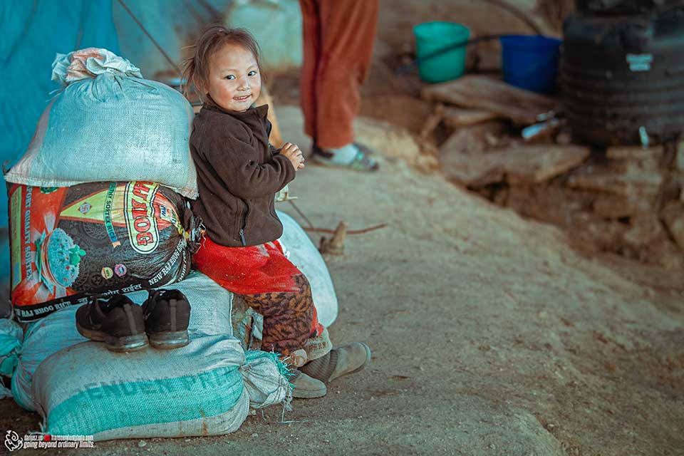 Dziewczynka opiera się o worek z ziarnem, Bhutan