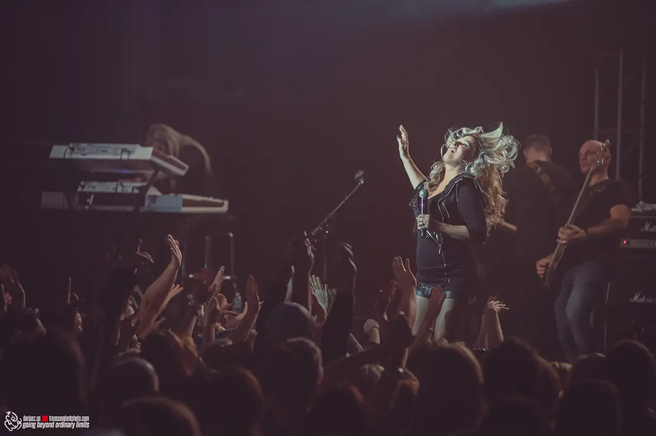 Female singer performing live to an engaged crowd.