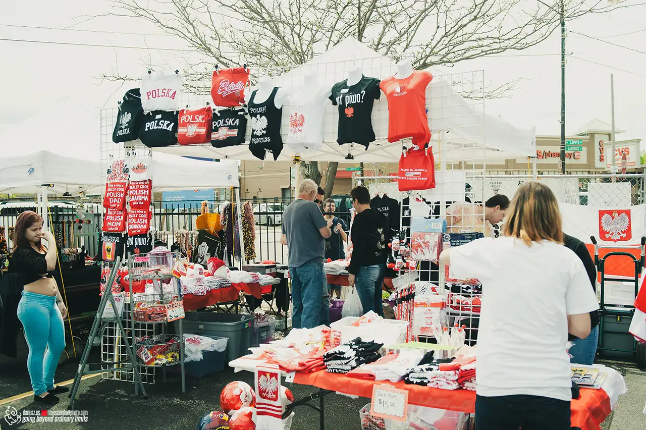 Outdoor market stall selling Polish-themed clothing and accessories.