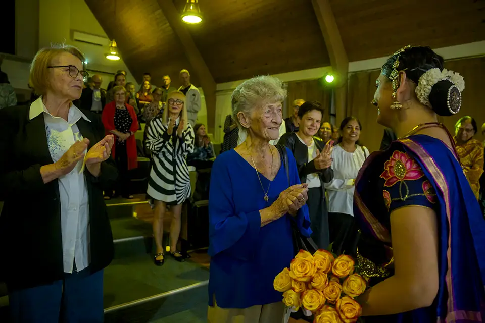 Dancer with roses receives applause from appreciative audience.
