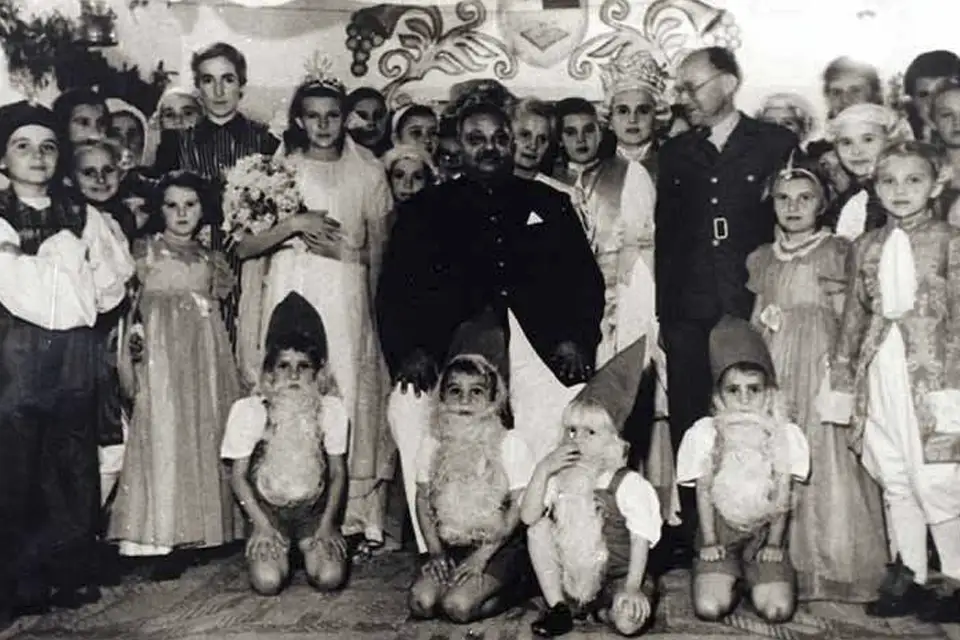 Vintage photo of adults and children in costumes, including gnomes.