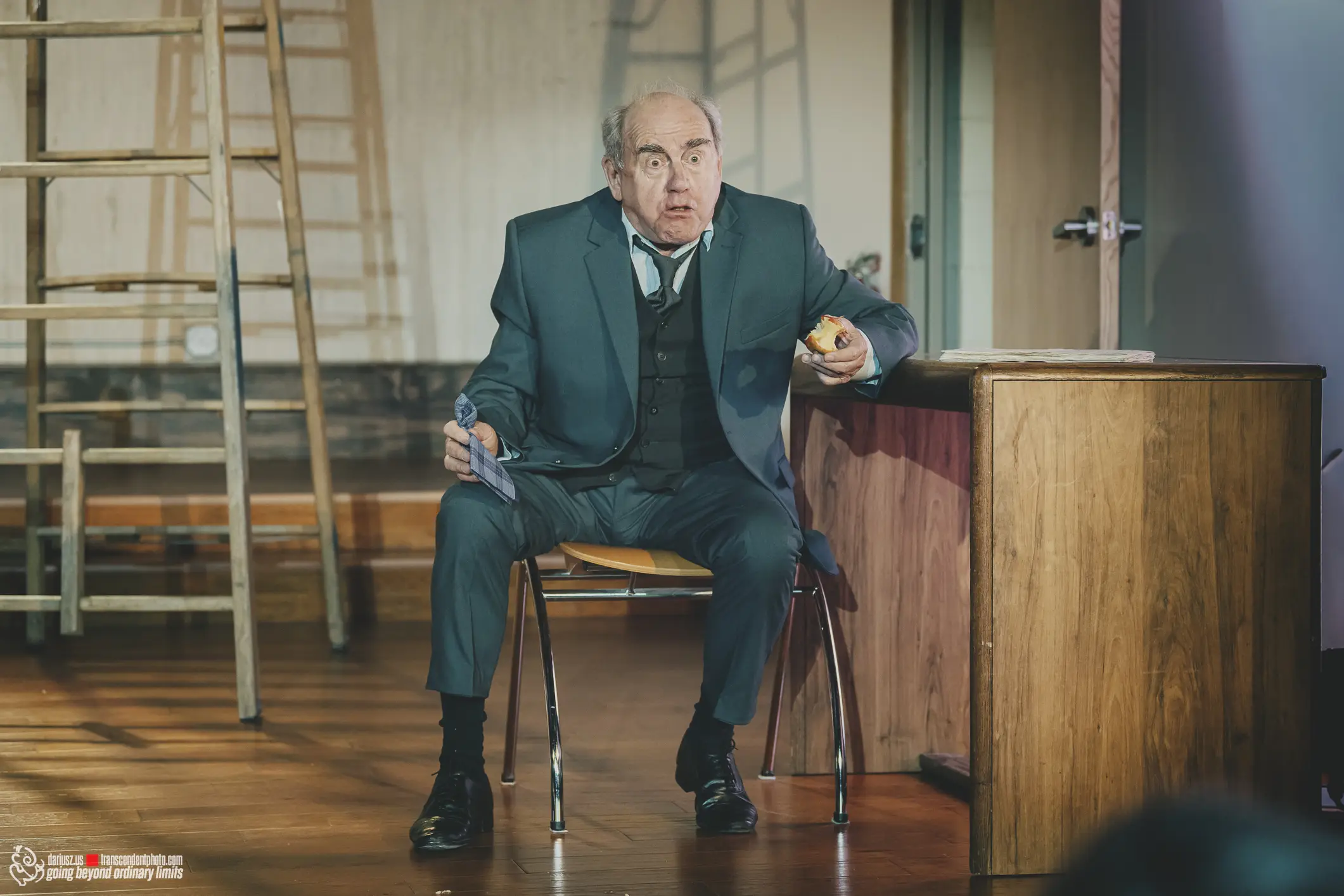 Surprised man in suit holding a tie and bitten apple core.