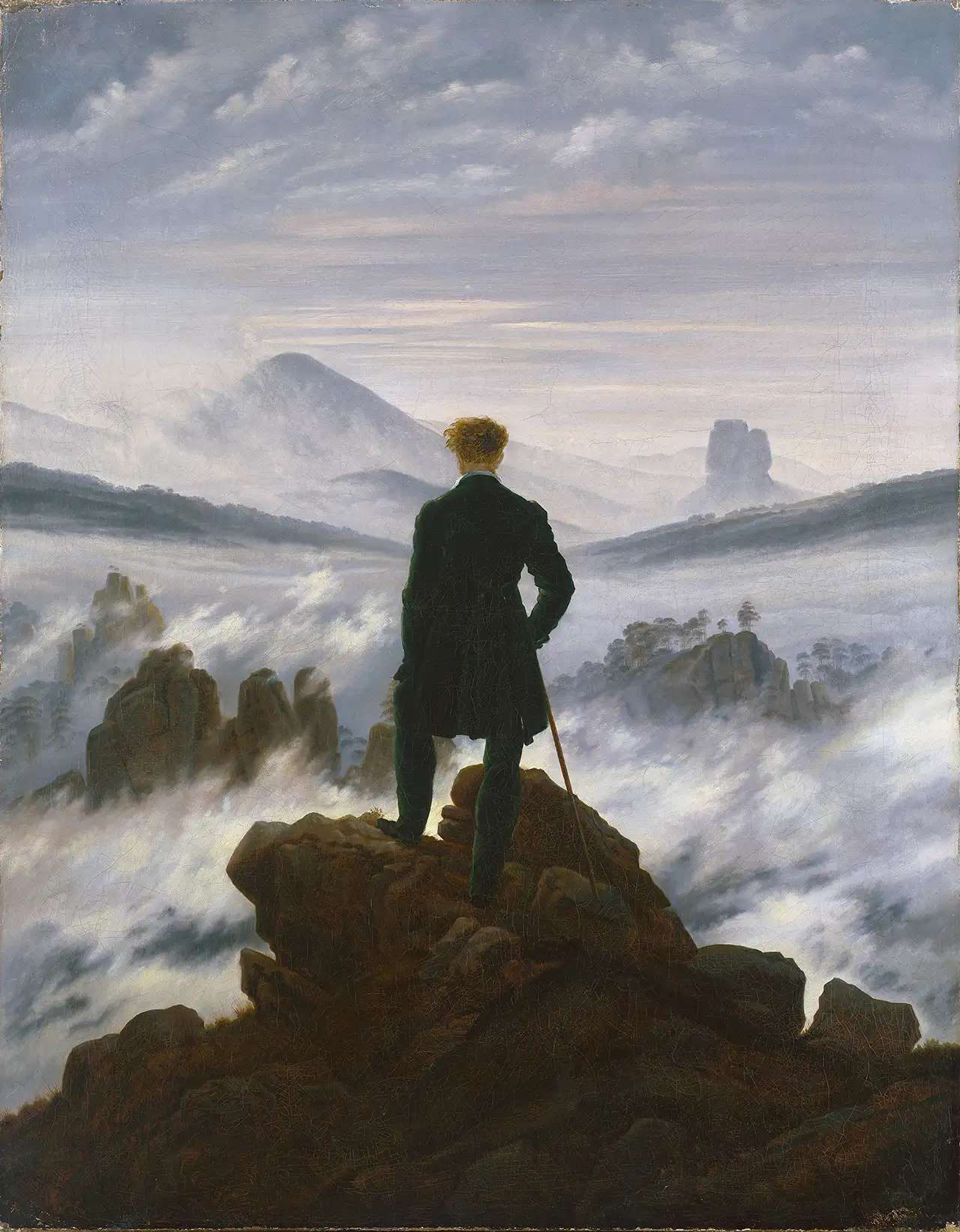 Wanderer above sea of fog, man overlooks misty mountain landscape.