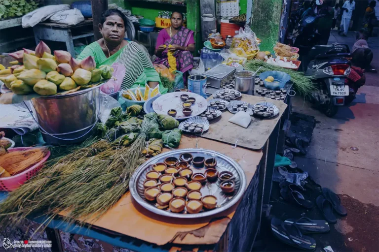 Women selling traditional lamps, lotus buds, and offerings at market.